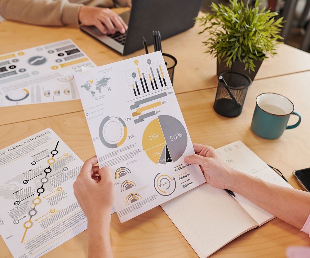 Business professionals analyzing printed data visualizations during a strategic planning session.