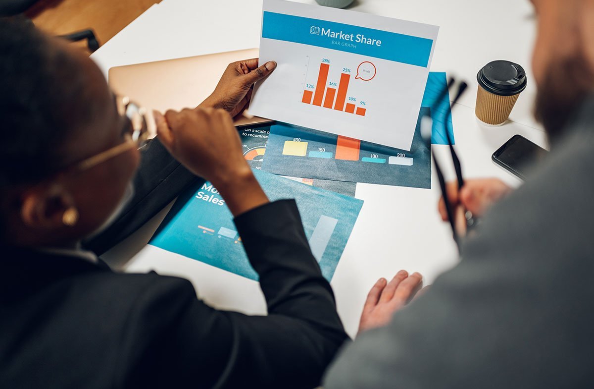 Professionals review a market share graph in a business meeting.