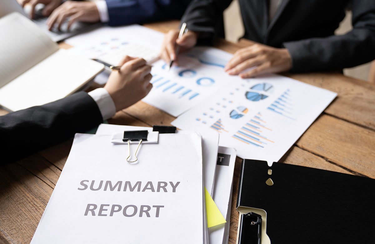 Business professionals analyzing a summary report with charts and data.